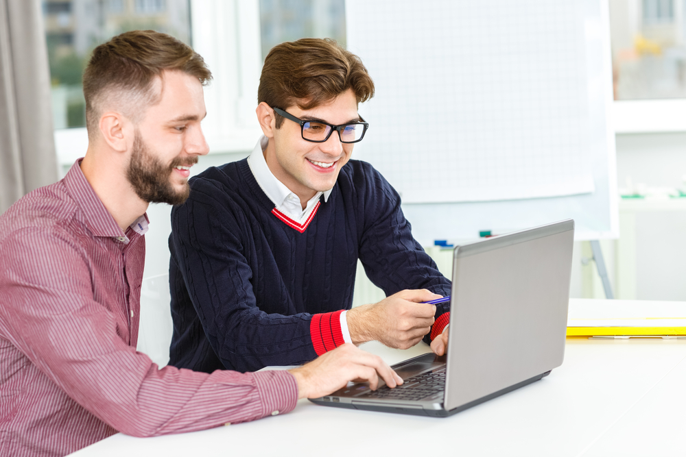 Discussing,Project.,Shot,Of,Two,Male,Co-workers,Working,Together,On